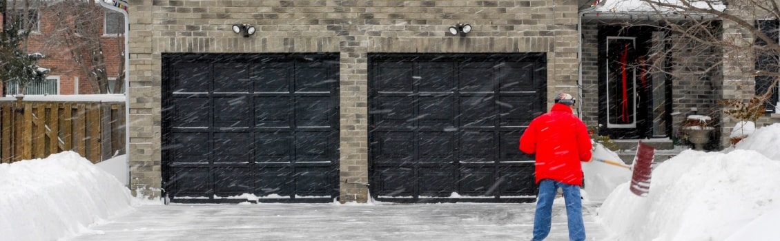 man removing snow on his driveway