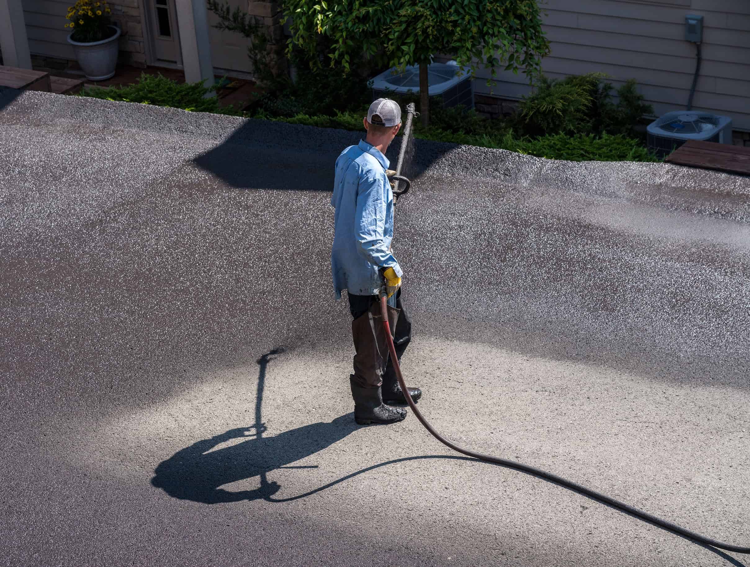 WCI driveway sealing contractors applying asphalt sealer in Ottawa